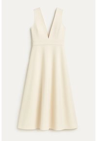 Robe crème sans manches avec un décolleté profond en V et une taille cintrée, s’évasant en jupe trapèze, présentée sur un fond uni.
