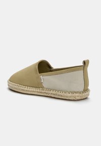 Beige espadrille met een gladde bovenkant en canvas zijkanten, voorzien van een natuurlijke jute zool en een kleine hak voor comfort.