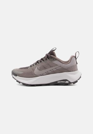 Vue latérale d'une chaussure de trail Nike grise avec tige en mesh, semelle blanche amortie et semelle extérieure noire.