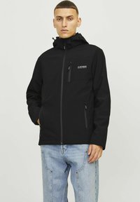 Juoda zip-up striukė su kapišonu, pagaminta iš minkštos medžiagos. Yra krūtinės kišenė ir dvi šoninės kišenės. Minimalistinis dizainas su logotipo akcentu.