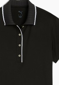 Svart pikétröja med strukturerad svart ribbad krage, vita detaljer, tre knappar i knappslån och korta ärmar. Materialet verkar vara slätt.