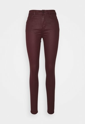 Braune, beschichtete Hose mit hohem Bund und schmaler Passform, vorne mit Knopf- und Reißverschluss, Gürtelschlaufen und Fünf-Taschen-Stil.