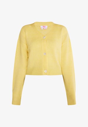 Kollane lühendatud kardigan pehmest, tekstuuriga materjalist. Omab V-kaelust, pikki varrukaid ning kolme nööbi esiosas.