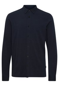 Camisa de botones de manga larga en azul marino oscuro con cuello, que presenta seis botones negros en la parte delantera.