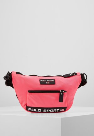 Brzoskwiniowo-różowa saszetka na pasek Polo Sport z czarnym regulowanym paskiem, dwiema przegrodami na zamek oraz naszywkami z logo Polo Sport i flagą amerykańską.