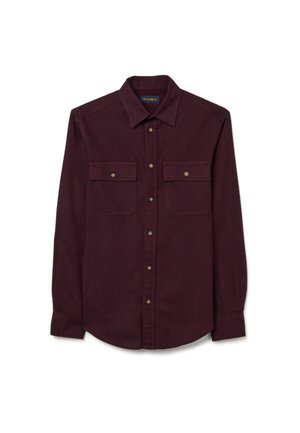 Bordeauxrode longsleeve gemaakt van zachte stof, met een knoopsluiting aan de kraag, twee borstzakken en ronde knopen.