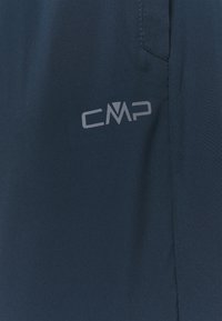 Marinblå utomhusbyxor gjorda av lättviktsmaterial med en CMP-logotyp på sidan. Har en sidficka och en mjuk yta.