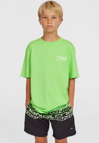 T-shirt di cotone verde brillante con logo O'Neill stampato sul petto, abbinata a pantaloni corti neri con una fascia in vita a motivo grigio.