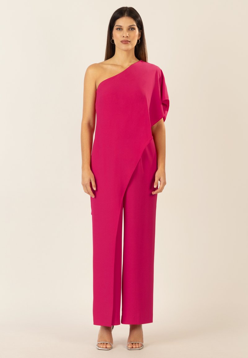 Mono fucsia con un solo tirante y patas anchas, confeccionado en tejido suave. Presenta un diseño asimétrico y un detalle drapeado en un lado.
