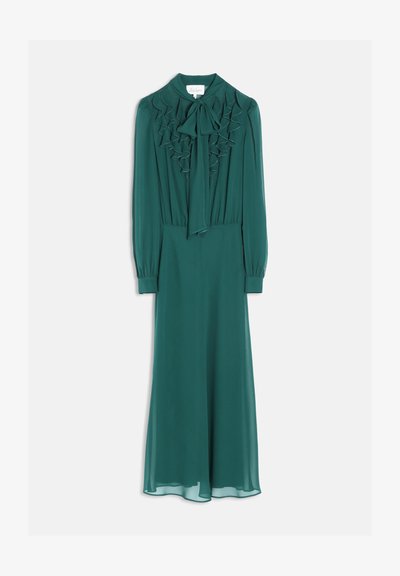 Robe longue vert sarcelle à manches longues, devant froncé et nœud noué au col, suspendue sur un fond blanc.