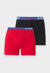 Δύο ανδρικά μποξεράκια, ένα κόκκινο και ένα μαύρο, το καθένα με μπλε μέση με την επιγραφή «NORWAY» με κόκκινα γράμματα και «BJÖRN» με λευκά γράμματα.