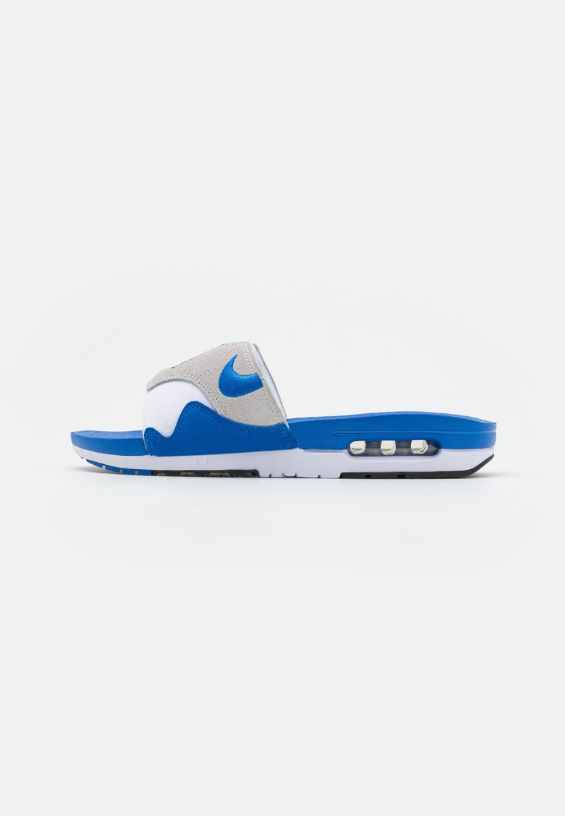 Sandale slide Nike bleu et blanc avec une bride grise ornée du logo Nike bleu et un coussin d'air visible dans la semelle.