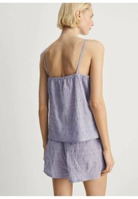 Ljust lila randig pyjamas set med tunna band, som har en luftigt passande topp och matchande shorts med en samlad midja.