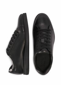 Czarne skórzane sneakersy o gładkiej powierzchni, okrągłym nosku i płaskich gumowych podeszwach. Posiadają czarne sznurowadła i oczka po bokach.