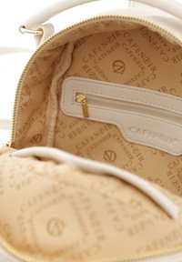 B�ílý kožený batoh uvnitř se zlatým zipem a boční kapsou. Podšitý béžovou látkou s opakovanými vzory "CAFE NOIR".