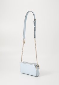 Světle modrá kabelka přes rameno z hladké kůže se zipem a zlatým řetízkovým popruhem. Jednoduchý obdélníkový tvar.