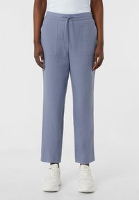Hellblaue, lockere Hose mit elastischem Bund und Kordelzug, ausgestattet mit zwei Vordertaschen und einer glatten Textur.