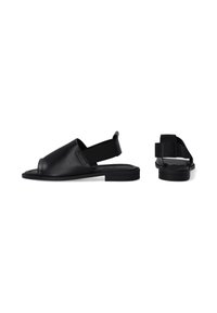 Zwarte leren slingback sandalen met een brede teenveter en een vlakke zool. Beschikt over een minimalistisch ontwerp en een elastische hielband voor een veilige pasvorm.