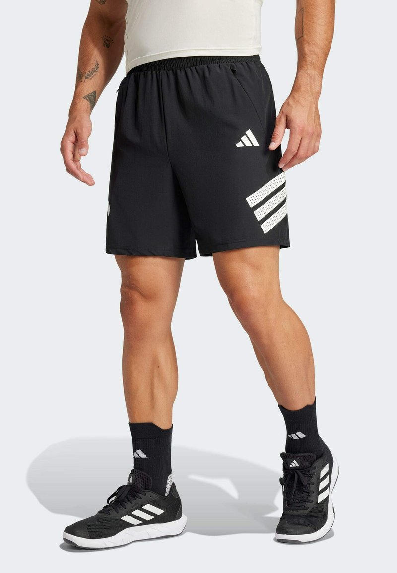 Schwarze Sportshorts mit drei weißen diagonalen Streifen und perforierten Akzenten an der Seite. Elastischer Bund und leichtes Material.