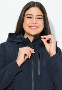 Námořnická mikina s kapucí a zipovým uzávěrem, elastickými manžetami. Měkká textura, lehký design, se stahovacími šňůrkami na kapuci.