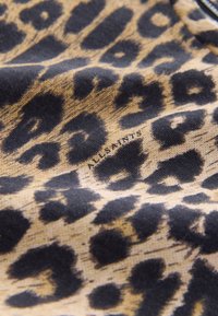 Leoprint-Stoff in Beige und Schwarz mit weicher Textur und einem Design aus unterschiedlich großen Flecken. Das Etikett trägt die Aufschrift "ALLSAINTS".