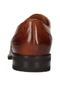Chaussure oxford en cuir marron avec des détails en brogue, forme arrondie et un talon empilé noir. Coutures visibles le long des coutures.