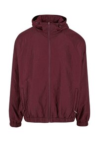 Ciemnoczerwona kurtka zapinana na zamek z kapturem, elastycznymi mankietami i dołem, dwoma bocznymi kieszeniami oraz subtelnie przyszytym wzorem na materiale.