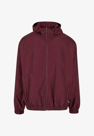 Donkerrode zip-up jack met capuchon, elastische boorden en onderrand, twee zijzakken en een subtiel genaaid patroon op de stof.