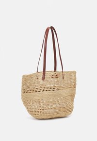 Geweven rieten tas met tan leren handvatten, met een open en luchtig ontwerp in een neutrale beige kleur. Textuur met horizontale strepen.