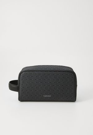 Black toiletry bag featuring a repeating "CK" logo pattern, made of a textured material with a leather handle and zip closure.