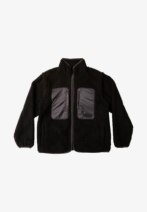 Musta fleece-takkia, jossa on korkea kaulus, edessä vetoketju ja kaksi harmaasta kankaasta valmistettua rintataskua. Pintakuvioitu pinta ja joustinat.