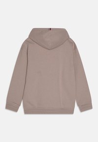 Felpa beige a maniche lunghe con cappuccio e polsini e orlo a costine, caratterizzata da un piccolo dettaglio a strisce tricolori sul colletto posteriore.