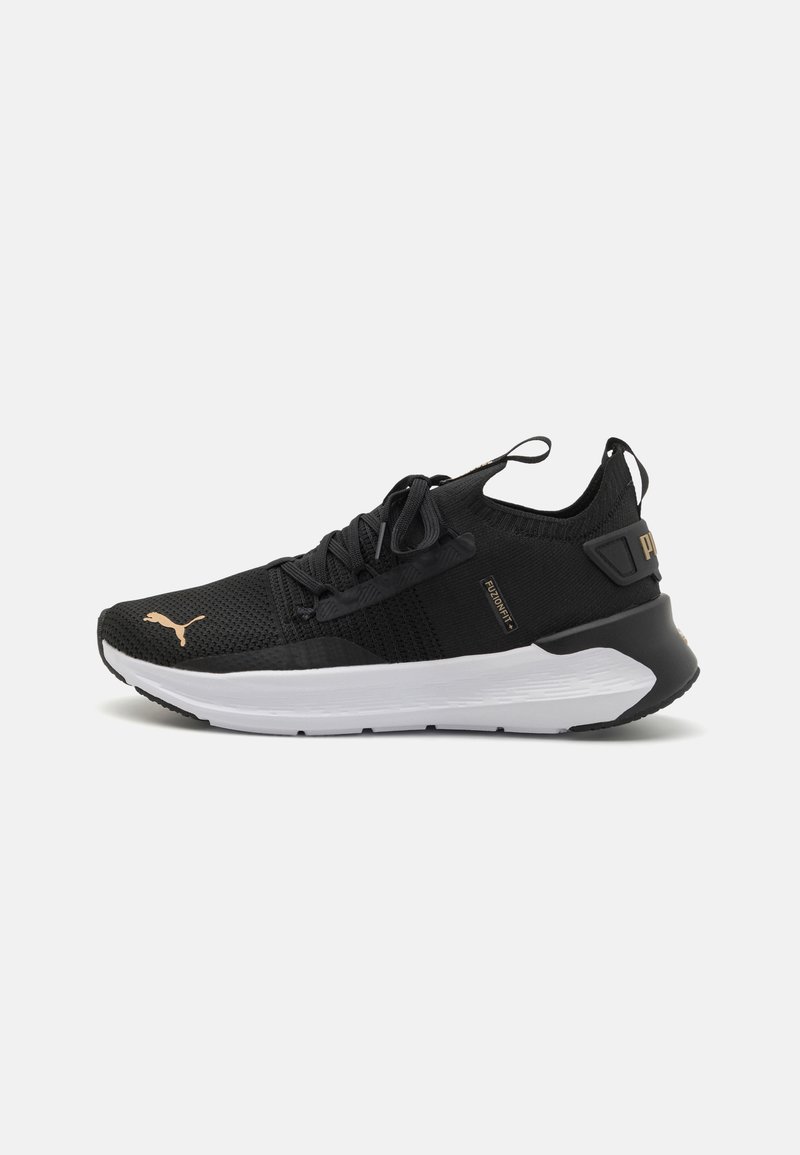 Black athletic shoes with a breathable mesh upper, white midsole, and gold accents. Features rounded toe and cushioned sole for comfort.