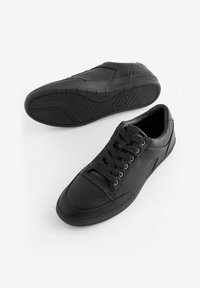 Czarne sneakersy z gładką skórzaną cholewką, teksturowanymi akcentami, perforowanymi panelami i gumową podeszwą z wzorzystą bieżnią.