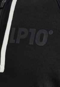 Zwarte sweatshirt met witte rits enkoord. Heeft een groot, matte "LP10" logo op de voorkant. Zachte,Textuurstof.