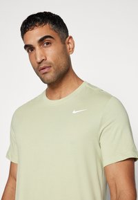Nike Performance CREW SOLID - Spordi T-särk - olive aura