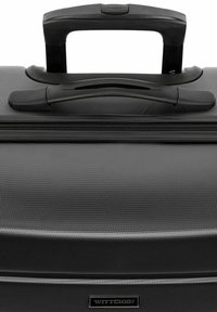 Valigia nera con texture, dotata di manico estensibile, cerniere lisce e etichetta del marchio. La superficie presenta un pattern fine e resistente.