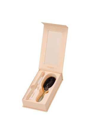 Beiges Pflegeset mit einer Haarbürste und einer weißen Zahnreinigungsbürste in einer passenden Box mit offenem Deckel und Spiegel innen.