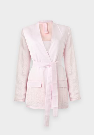 Light pink long-sleeve blazer with textured fabric, two front flap pockets, and a matching fabric belt tied at the waist.
