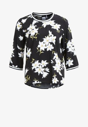 Chemise noire à manches longues avec imprimé floral blanc, col rond et poignets rayés blancs.