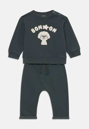 Mørk grønn todlerantrekk med langermet genser som har en tegneseriehund med briller og teksten "BON ON", sammen med matchende bukser.