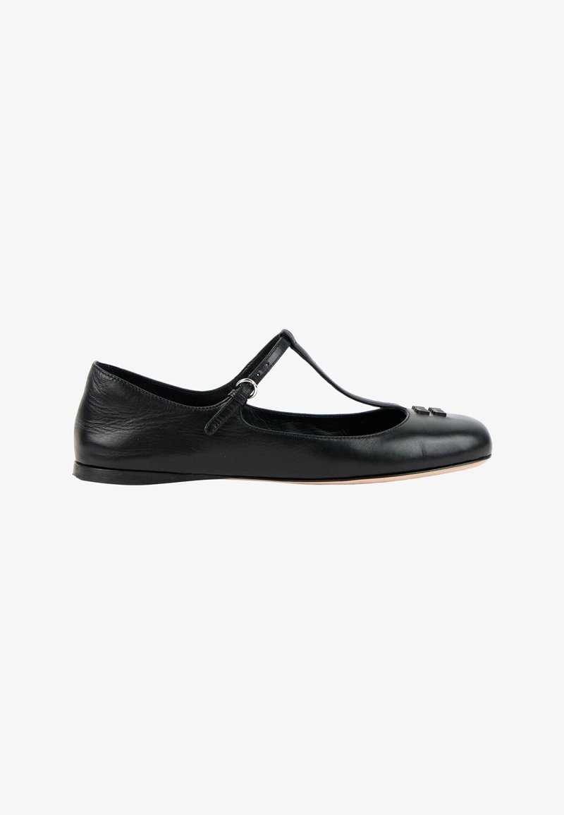 Chaussure plate Mary Jane en cuir noir avec bride en T et petite boucle, ornée d'un nœud décoratif sur le bout arrondi et une semelle fine.