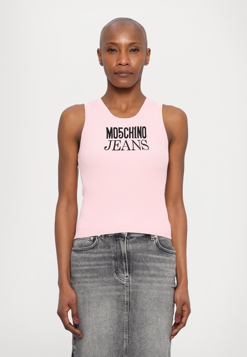 Top de alças rosa canelado com "MOSCHINO JEANS" em texto preto em contraste, combinado com uma saia de denim cinza.