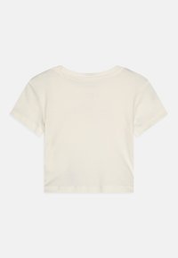 Avkortet t-skjorte i off-white bomull. Korte ermer, rund hals og glatt tekstur. Enkelt design uten synlige logoer eller mønstre.