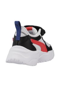 Sneaker bianco e nero con accenti rossi, collare imbottito, cinturino regolabile, tomaia in pelle e mesh testurizzata, suola bianca spessa, linguetta del tallone blu.