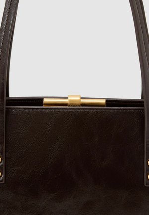 Melnas teksturētas ādas soma ar zelta aparatūru aizdarei, divām rokturiem un smalkām šuvēm sānos.