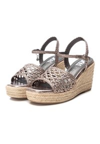 Sandali wedge in bronzo metallicoriccio con texture intrecciata, cinturino alla caviglia e piattaforma avvolta in juta. Tenuta interna liscia, design leggero.