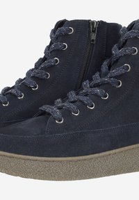Marineblaue Wildleder Stiefeletten mit einer strukturierten Sohle, geflochtenen Schnürsenkeln und einem inneren Reißverschluss für einfaches Anziehen. Silberne Ösen betonen das Design.