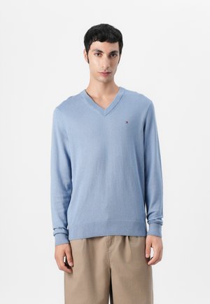 Lichtblauw v-hals sweater van een zachte brei-stof met lange mouwen en ribgebreide manchetten. Bevat een klein logo op de borst en heeft een relaxte pasvorm.