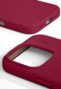 Burgunder mobildeksel med en jevn matt finish, utskjæringer for porter og preget merkevare på siden for grep og stil.
